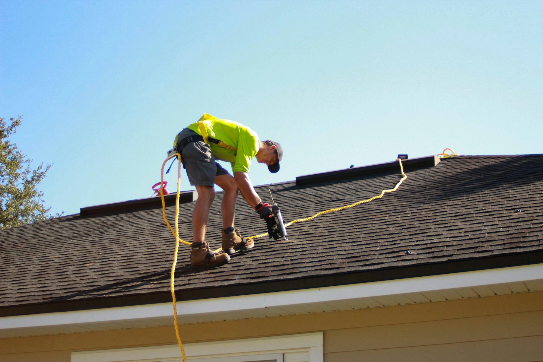 Roofer installing shingles on a house
