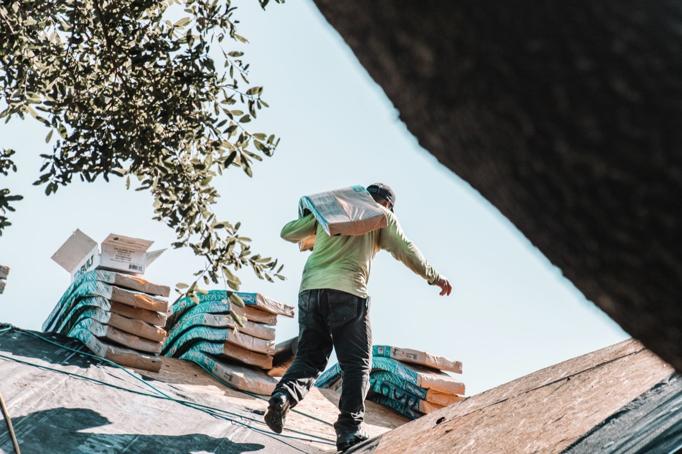 Roofer carrying a bundle of shingles