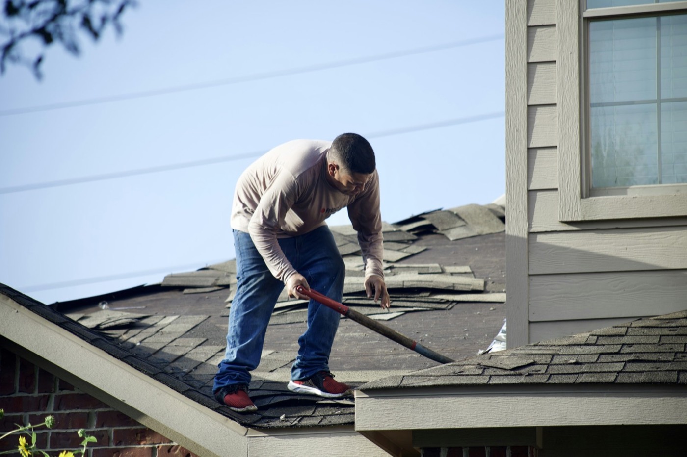 Roofer removing old shingles